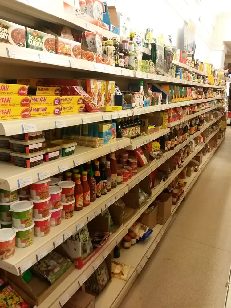 Shelves of Golden Curry, Maysan curry paste and bottled sauces along a narrow aisle